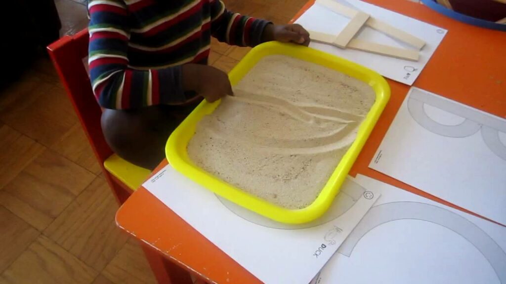 Attività sensoriali Montessori - lavagna di sabbia